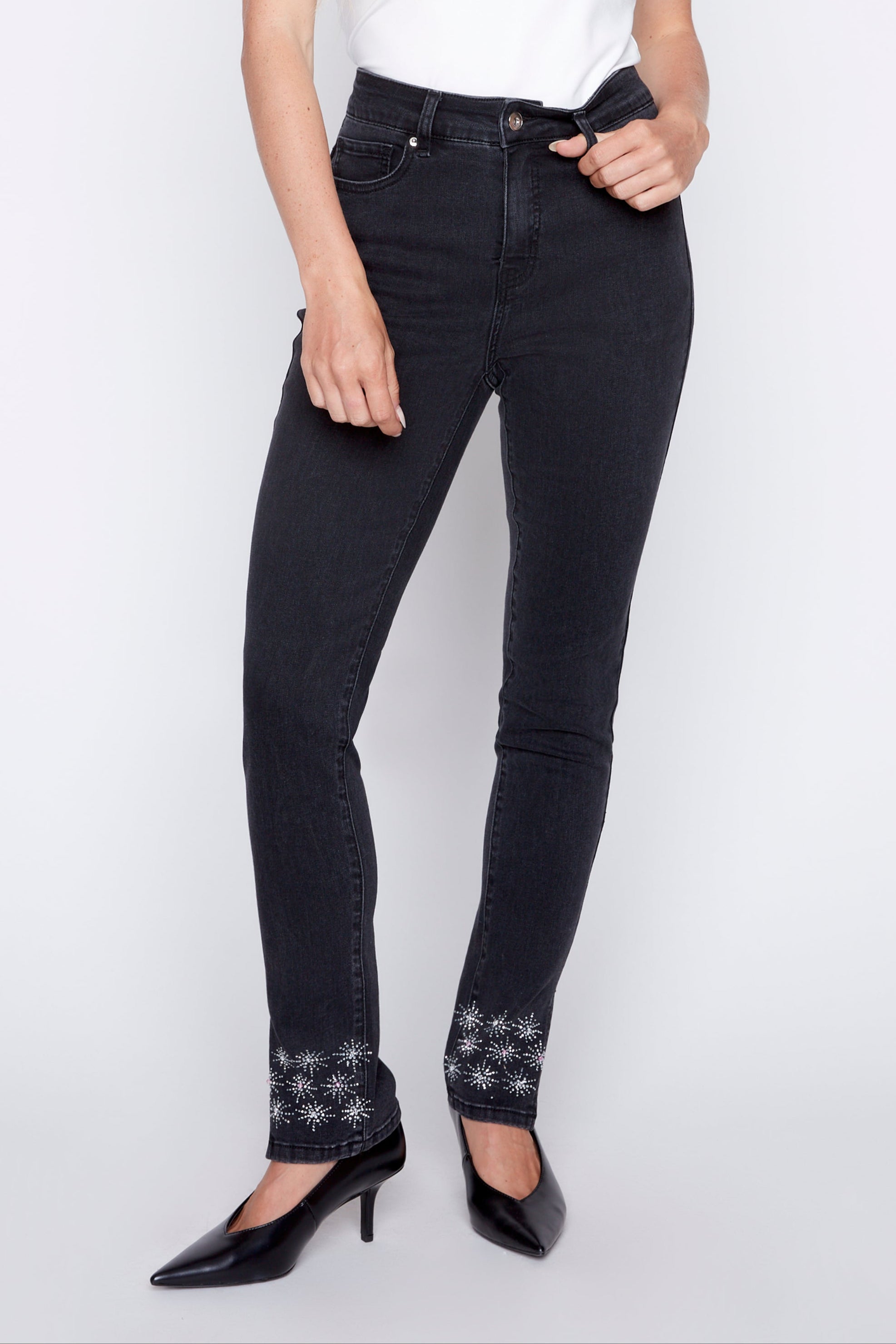 Woman wearing black jeans and a white top on a white background