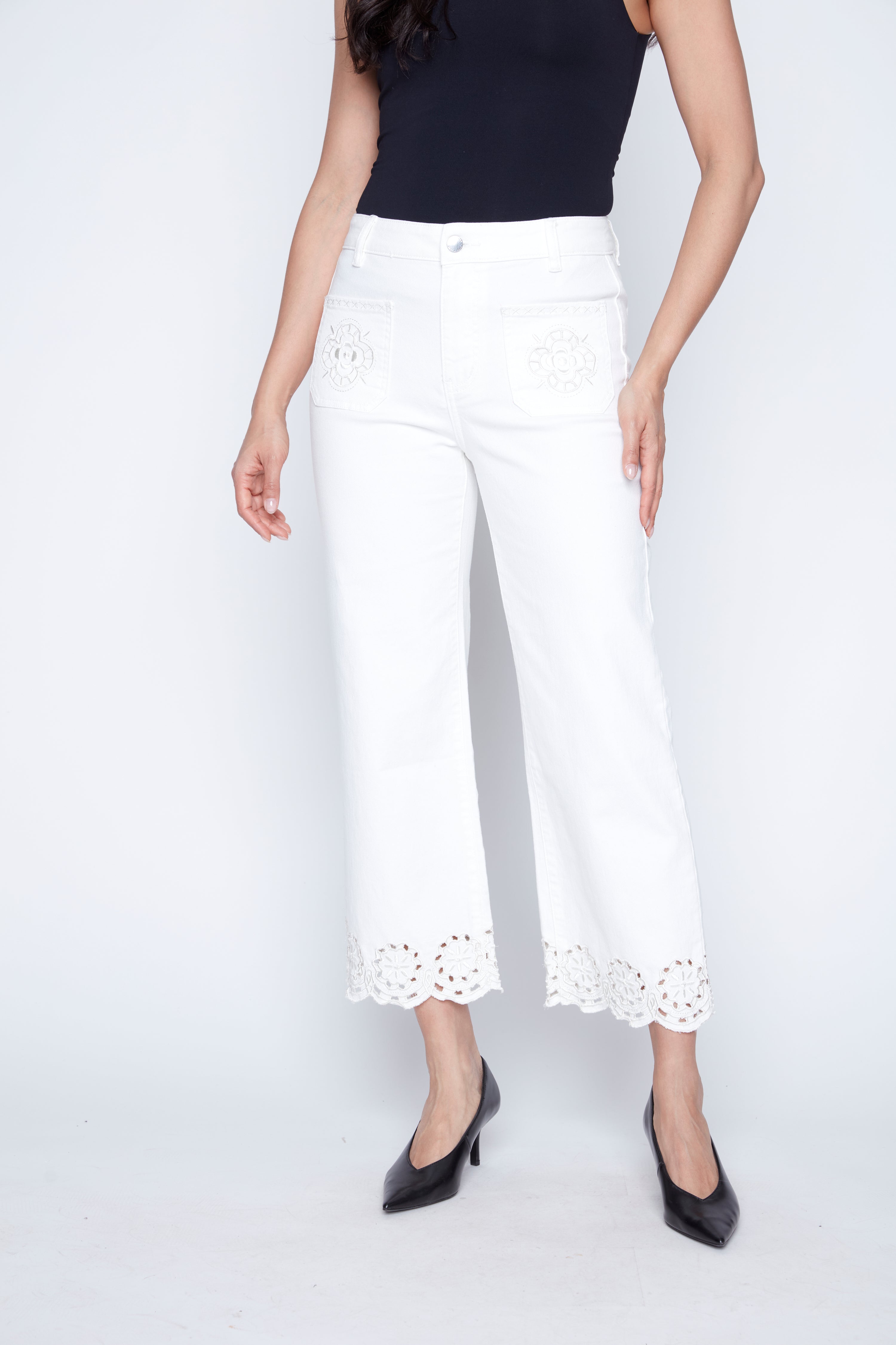Le jean à jambes évasées et ourlet brodé d'œillets