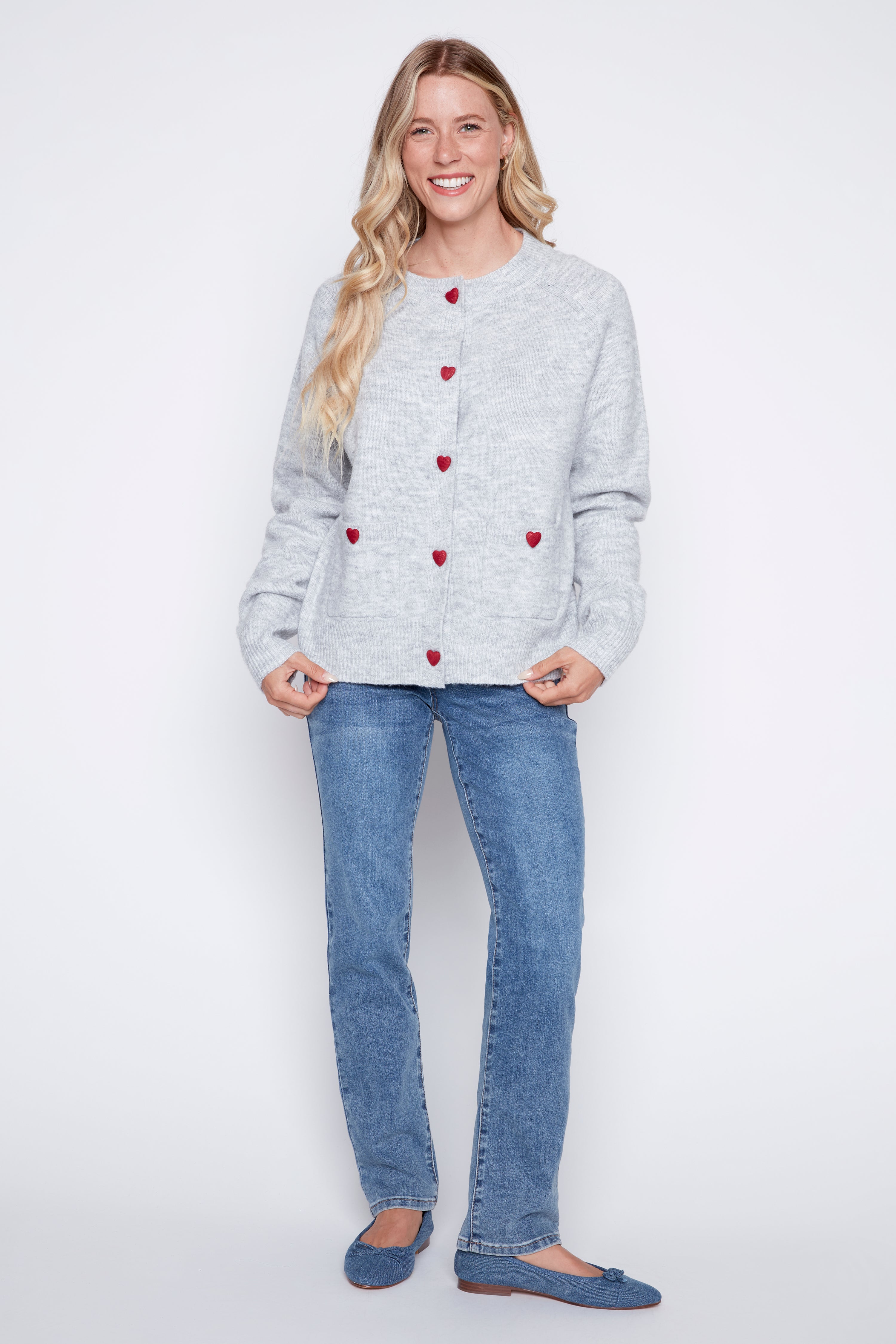 Le cardigan avec boutons à cœurs rouges