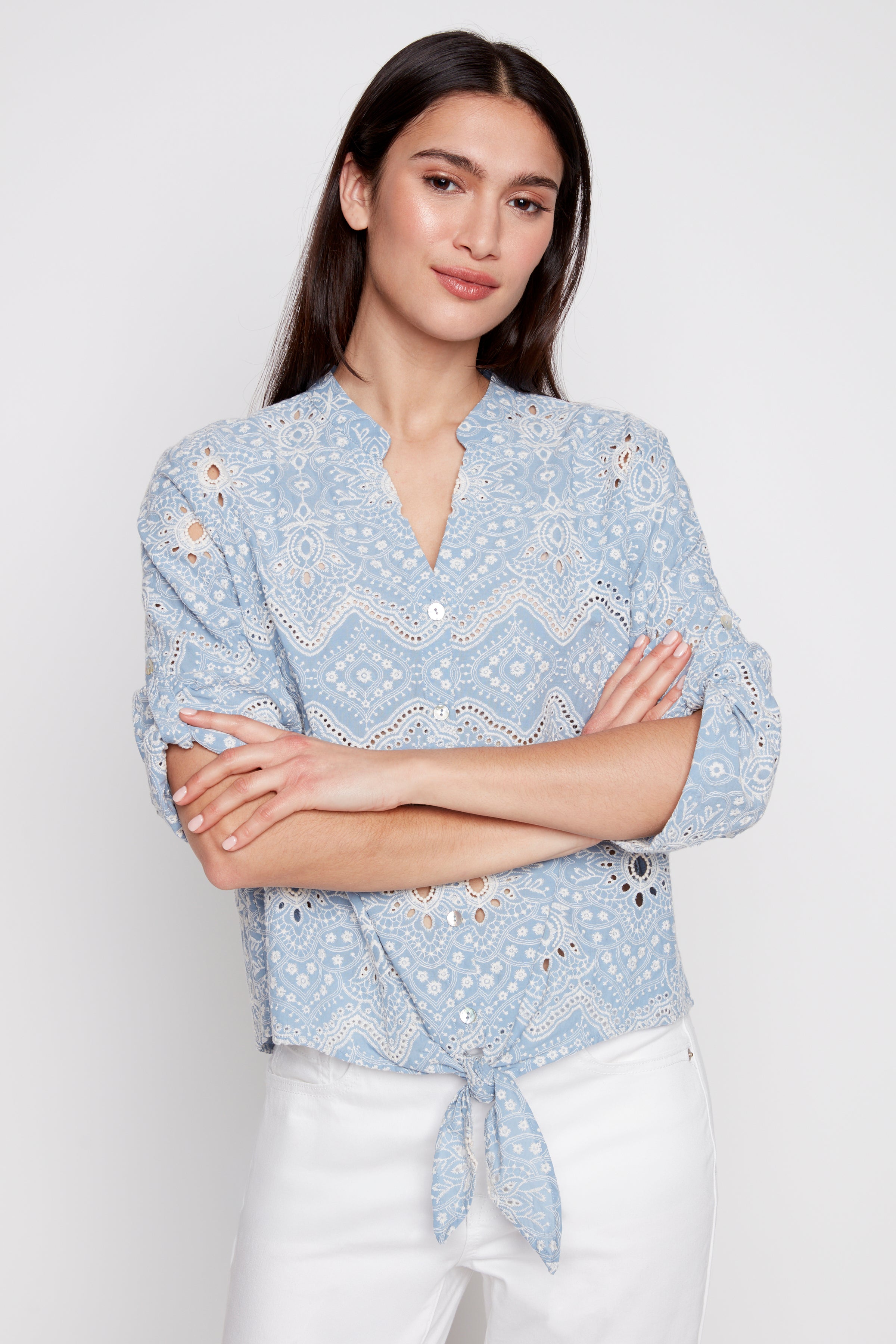 La blouse en coton brodée d'œillets et nouée sur le devant